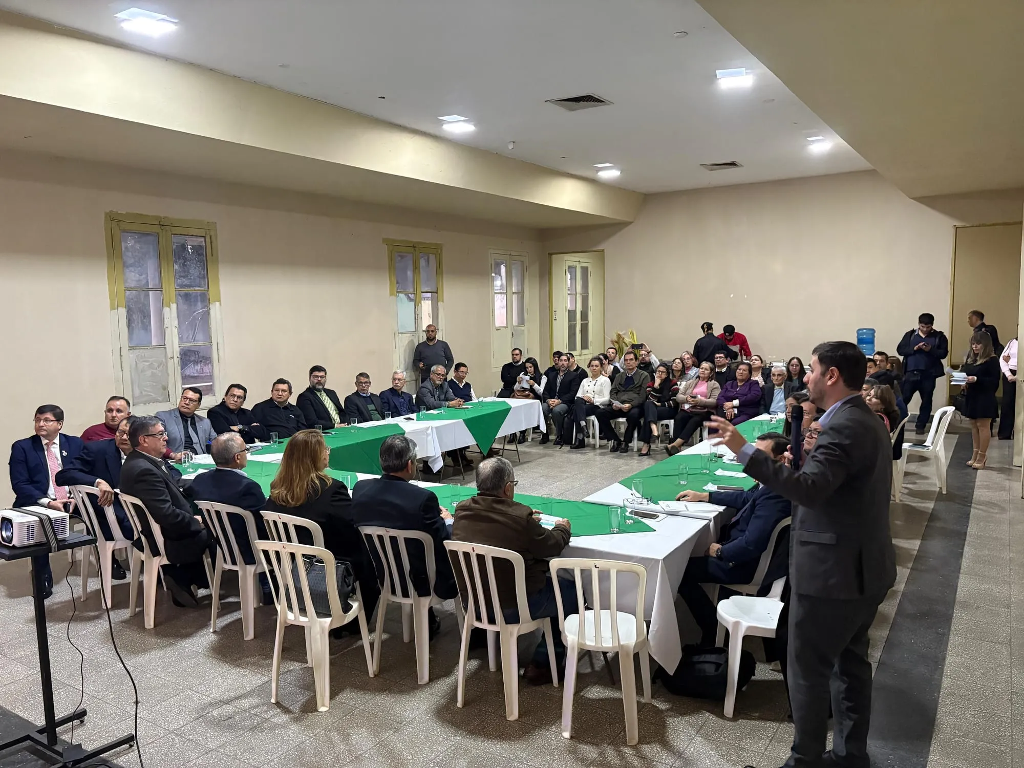 Exposición del programa del curso ante los asistentes, micrófono en mano