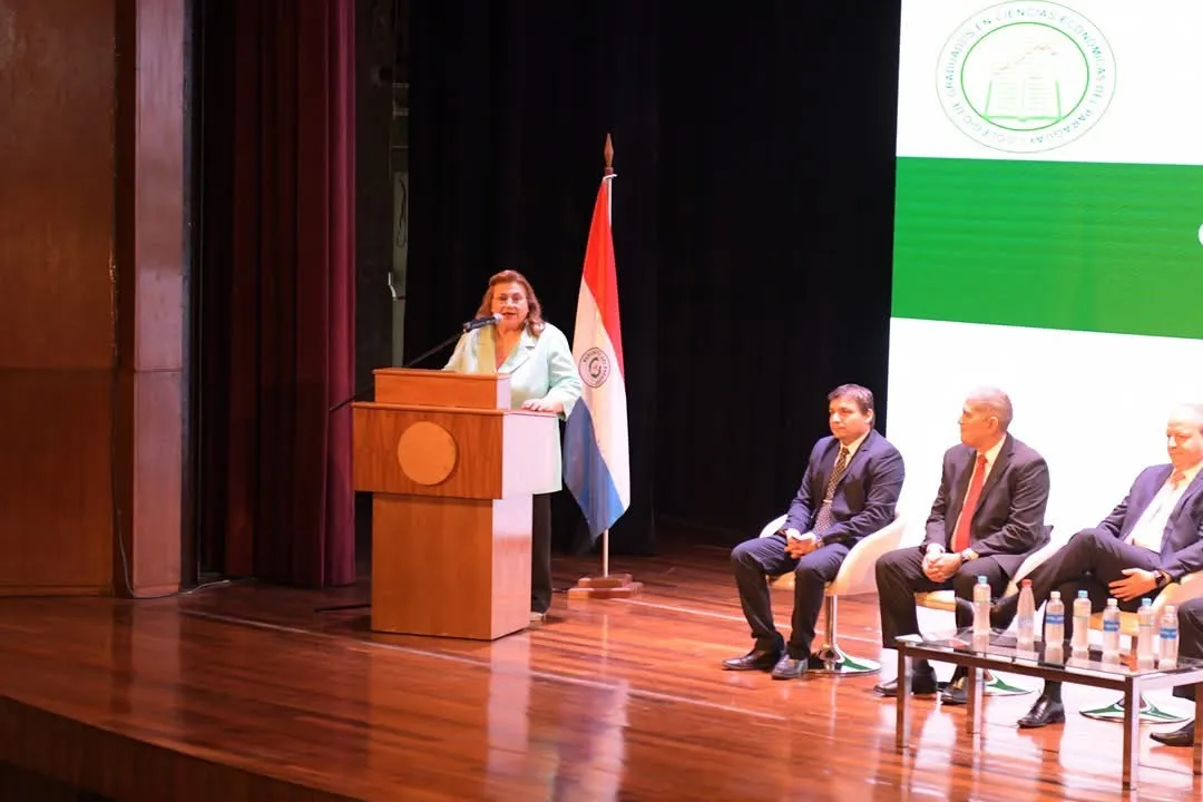 La Presidenta del Colegio en el atril durante el acto de apertura, junto a la mesa de autoridades