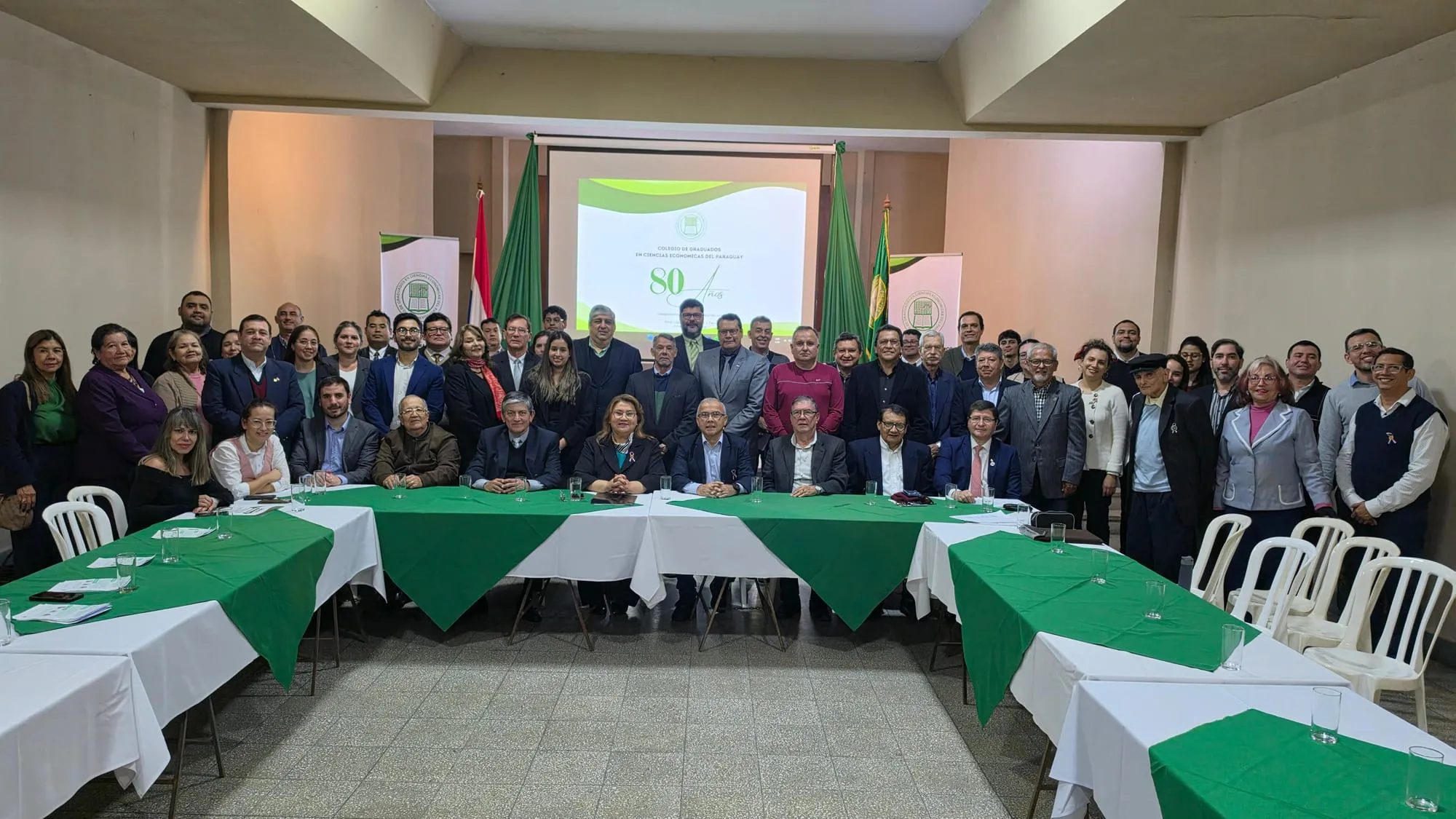 Foto grupal de todos los asistentes al lanzamiento, detrás de las mesas del salón